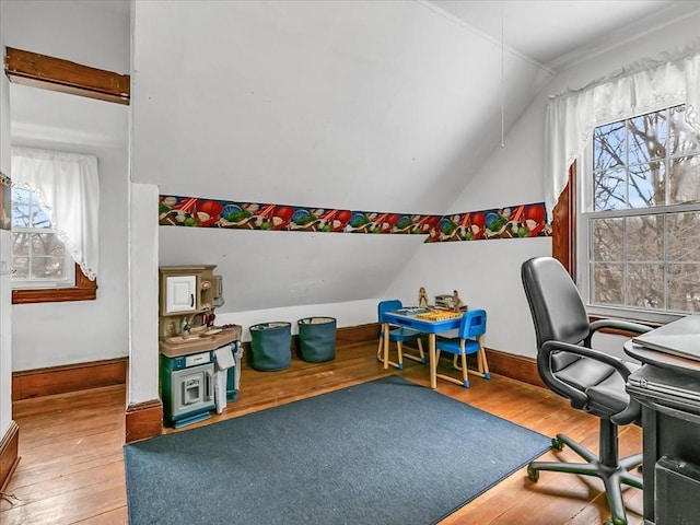 office area featuring baseboards, vaulted ceiling, and hardwood / wood-style floors