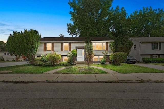 raised ranch featuring a front lawn