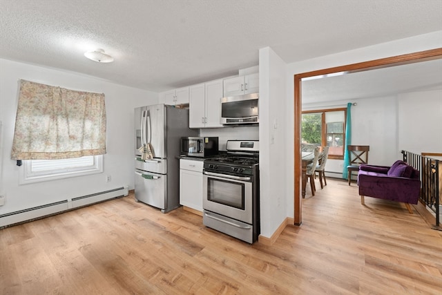 kitchen with light hardwood / wood-style flooring, white cabinets, stainless steel appliances, and a baseboard radiator