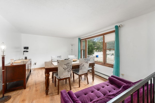 dining area featuring a baseboard radiator and light hardwood / wood-style floors