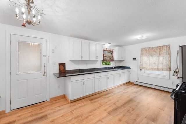 kitchen with black / electric stove, white cabinetry, sink, and a baseboard radiator