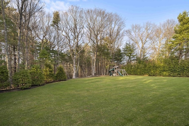 view of green lawn with a playground