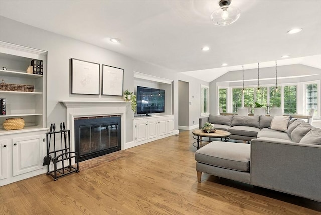 171 Brentwood Cir, North Andover, MA 01845 - living area featuring light wood finished floors, a glass covered fireplace, vaulted ceiling, recessed lighting, and built in features