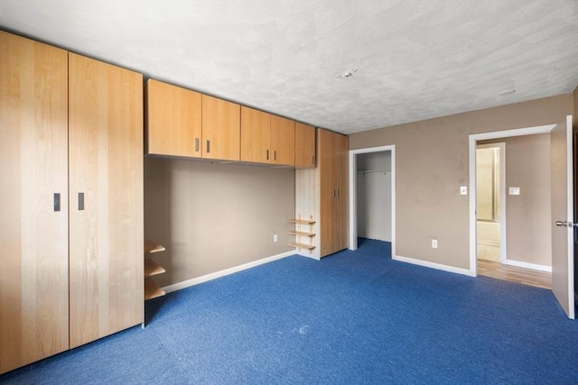 unfurnished bedroom featuring dark carpet and a textured ceiling