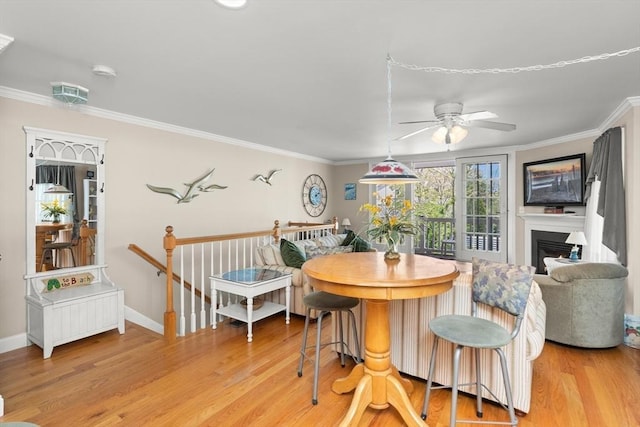 16 Ocean St Unit A, Salisbury, MA 01952 - dining room featuring light wood-style flooring, a ceiling fan, ornamental molding, and a fireplace