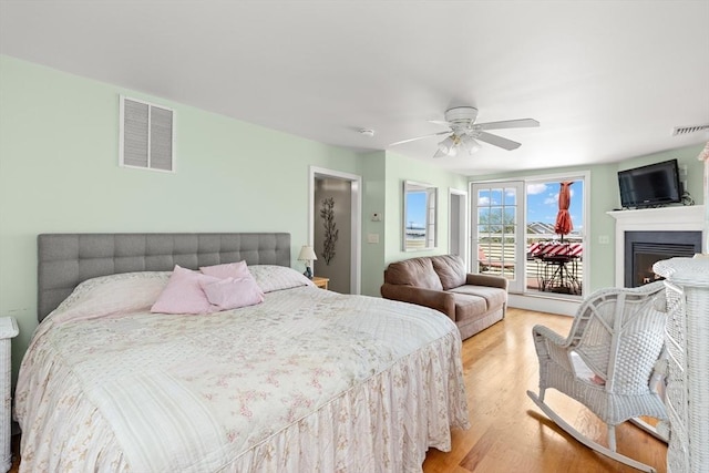 16 Ocean St Unit A, Salisbury, MA 01952 - bedroom with access to outside, light wood-type flooring, a fireplace, and a ceiling fan