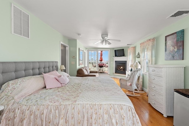 16 Ocean St Unit A, Salisbury, MA 01952 - bedroom featuring light wood-style floors, a lit fireplace, and ceiling fan