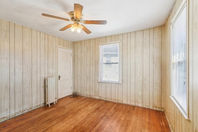 45 Franklin Ave, Quincy, MA 02170 - unfurnished room featuring wood walls, wood finished floors, a healthy amount of sunlight, and radiator heating unit