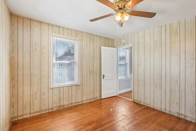 45 Franklin Ave, Quincy, MA 02170 - unfurnished room featuring a wealth of natural light, wooden walls, wood finished floors, and a ceiling fan