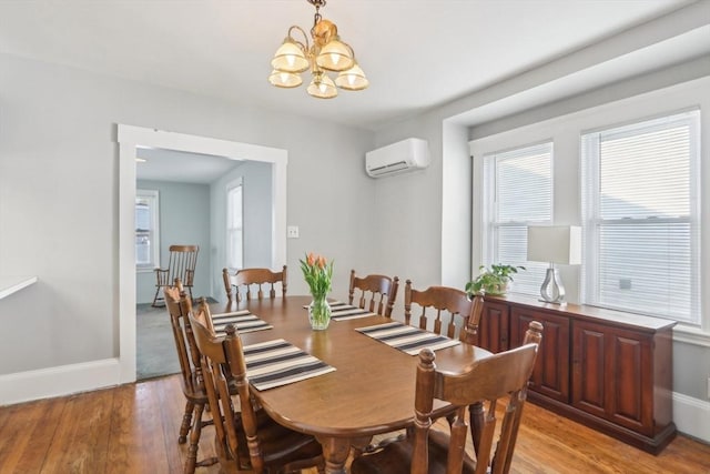 45 Franklin Ave, Quincy, MA 02170 - dining area with baseboards, a notable chandelier, light wood-style floors, and an AC wall unit