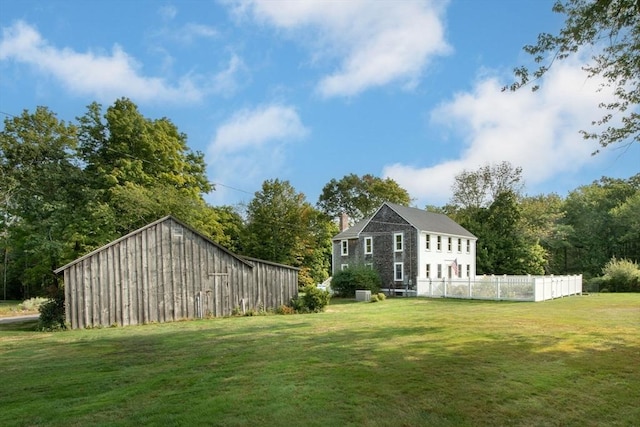 view of yard featuring an outbuilding and fence