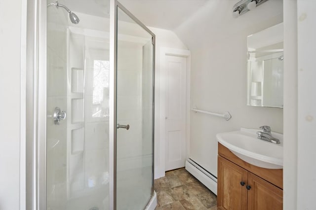 bathroom with baseboard heating, vanity, an enclosed shower, and vaulted ceiling