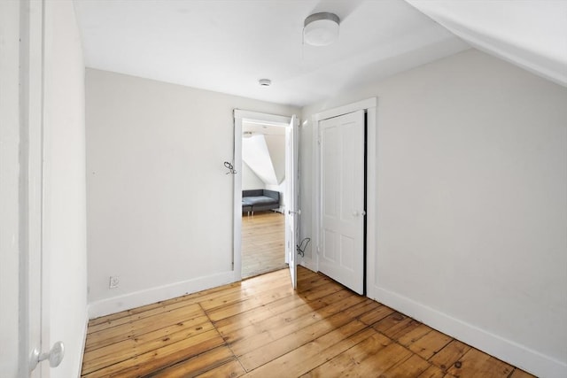 unfurnished bedroom with lofted ceiling and light wood-type flooring