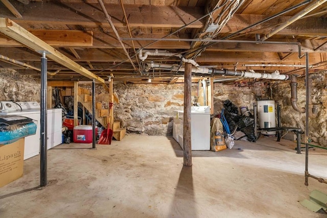 basement with electric water heater and washer and dryer