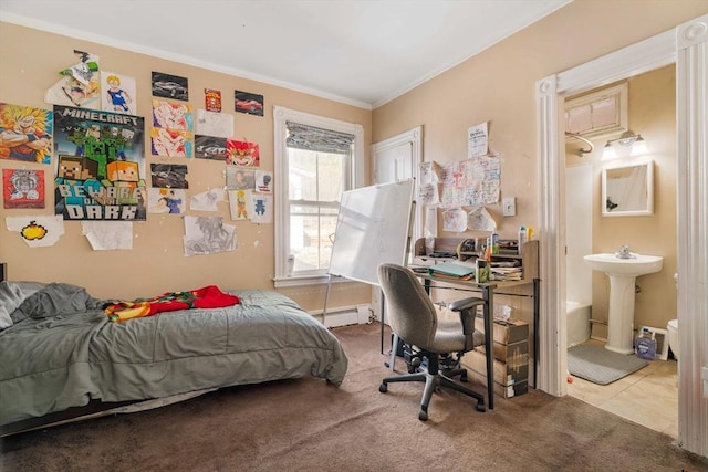 carpeted bedroom with crown molding, a baseboard heating unit, sink, and ensuite bath