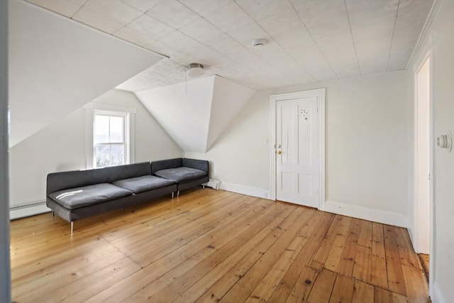 sitting room with lofted ceiling, a baseboard radiator, and light hardwood / wood-style floors