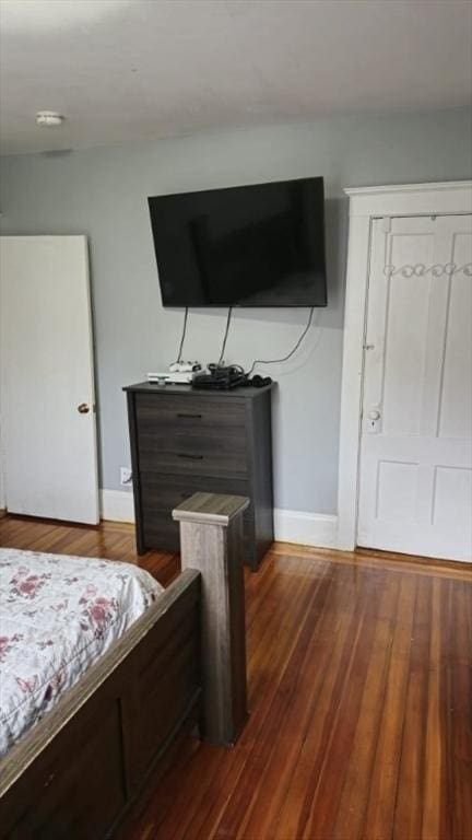 bedroom with dark wood-type flooring