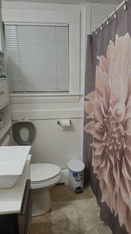 bathroom featuring vanity, toilet, tile patterned flooring, and walk in shower