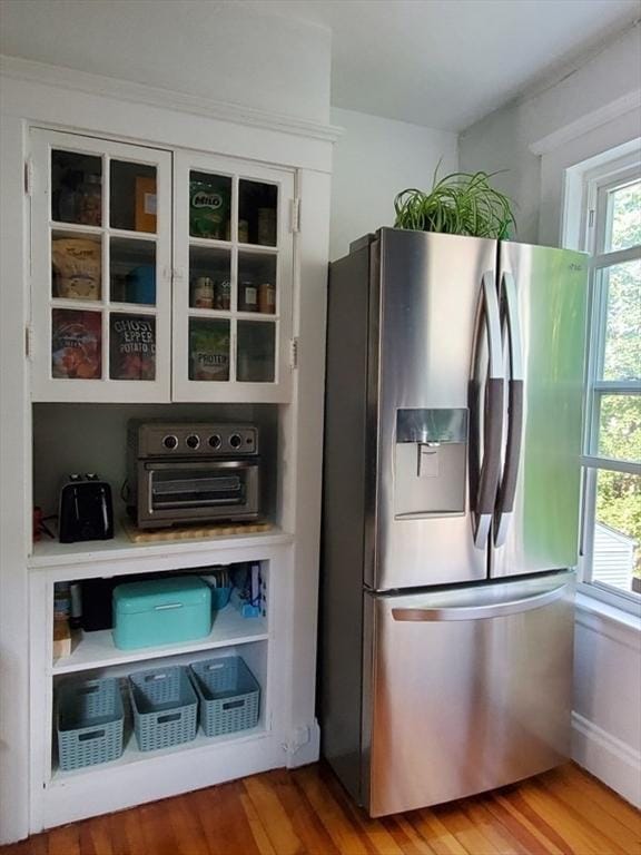 kitchen with stainless steel fridge with ice dispenser, hardwood / wood-style flooring, and a wealth of natural light