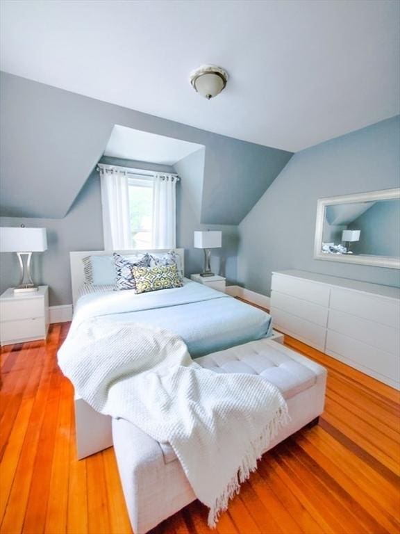 bedroom featuring light hardwood / wood-style floors and vaulted ceiling