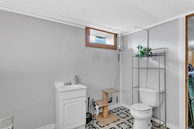 bathroom featuring a textured ceiling, vanity, and toilet