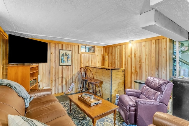 living room with a textured ceiling and wooden walls