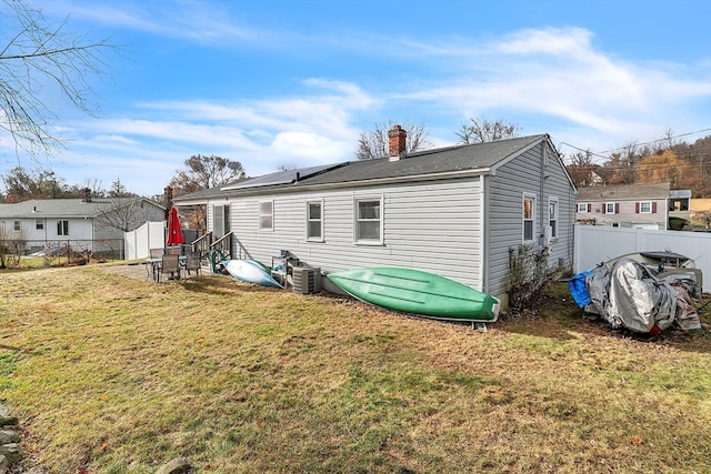 rear view of house featuring a yard and cooling unit