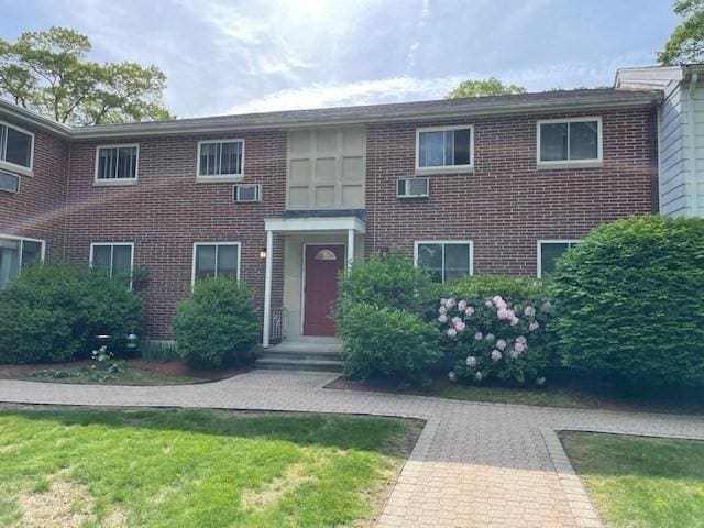 50 Wilson Dr Unit 50, Framingham, MA 01702 - view of front of home with brick siding, a front yard, and an AC wall unit