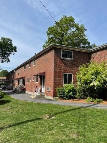 50 Wilson Dr Unit 50, Framingham, MA 01702 - back of property featuring a lawn, brick siding, and a patio