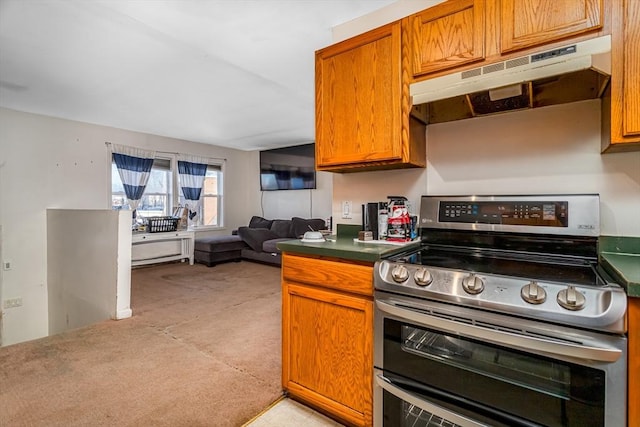 kitchen with dark countertops, brown cabinetry, open floor plan, double oven range, and under cabinet range hood