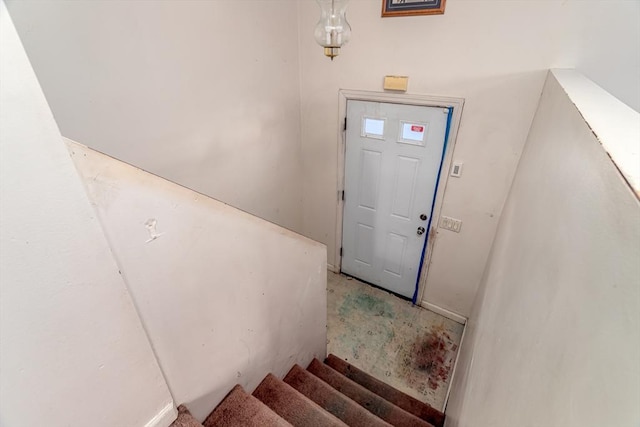 stairs featuring concrete flooring