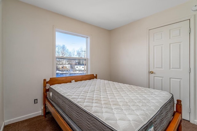 bedroom with baseboards and dark carpet