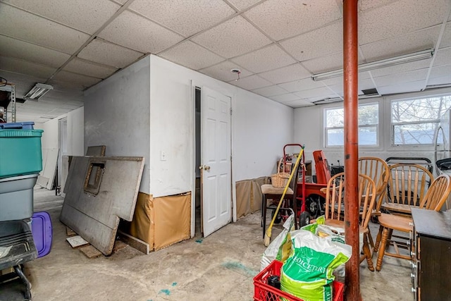 interior space featuring a paneled ceiling and unfinished concrete flooring