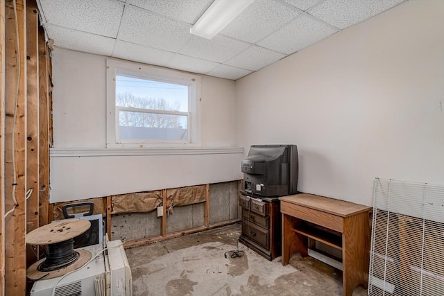 misc room featuring concrete floors and a drop ceiling