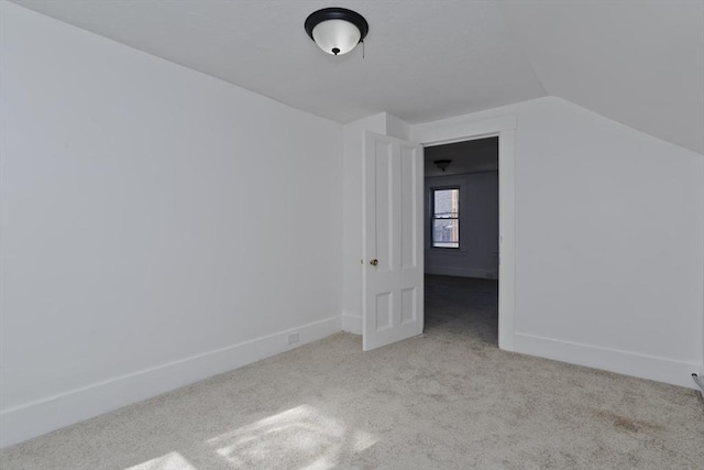 additional living space with baseboards, carpet, and vaulted ceiling