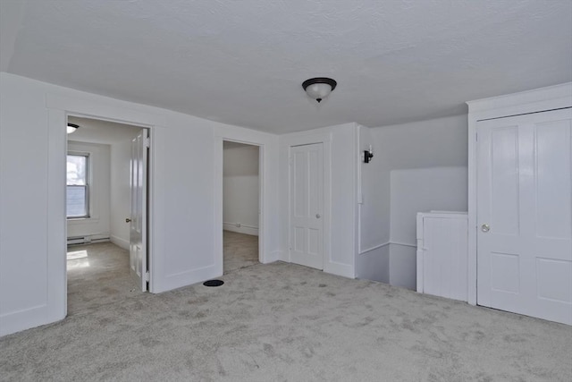 unfurnished bedroom with a baseboard radiator, baseboards, and carpet flooring