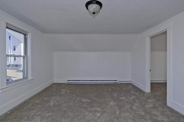 additional living space with a baseboard heating unit, lofted ceiling, and carpet floors