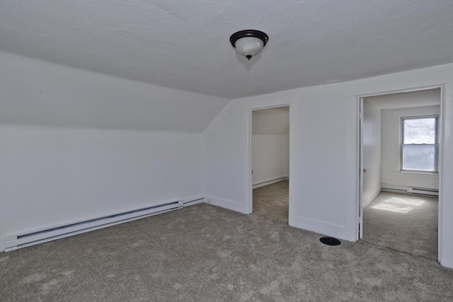 additional living space featuring a baseboard heating unit, lofted ceiling, a textured ceiling, and carpet flooring