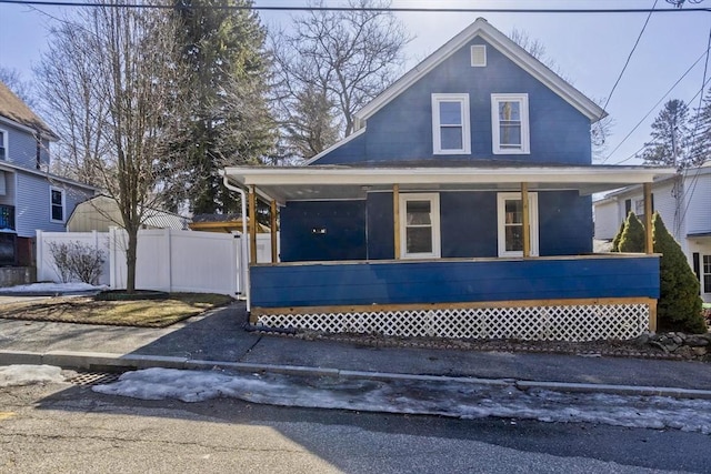 view of front of property featuring covered porch and fence