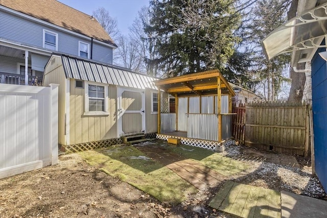 rear view of house featuring an outbuilding, a shed, and a fenced backyard