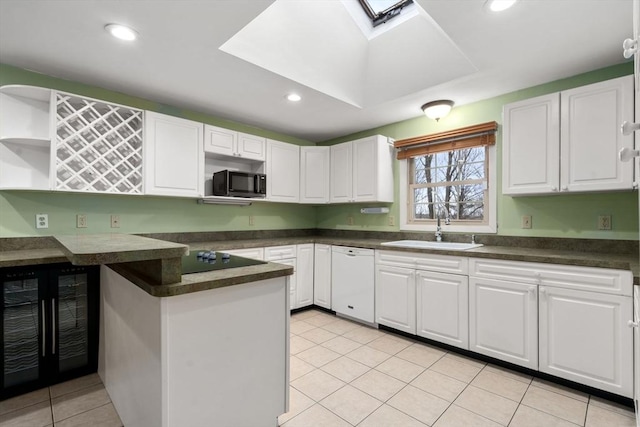 kitchen featuring white dishwasher, white cabinets, sink, light tile patterned flooring, and beverage cooler