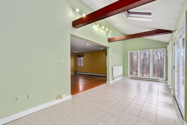 tiled empty room with a baseboard radiator and lofted ceiling with skylight