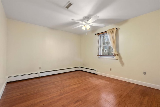 empty room featuring ceiling fan, wood-type flooring, and a baseboard heating unit