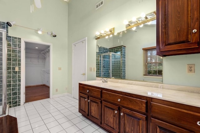 bathroom with tile patterned flooring, vanity, a shower with door, and ceiling fan