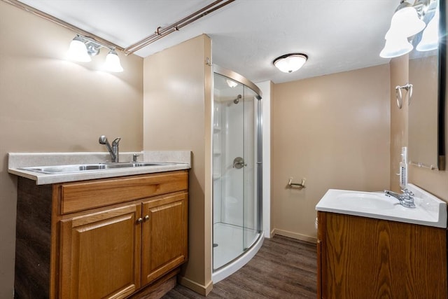 bathroom with vanity, wood-type flooring, and a shower with shower door