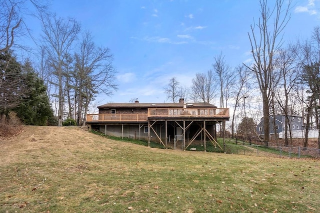 back of house featuring a lawn and a deck