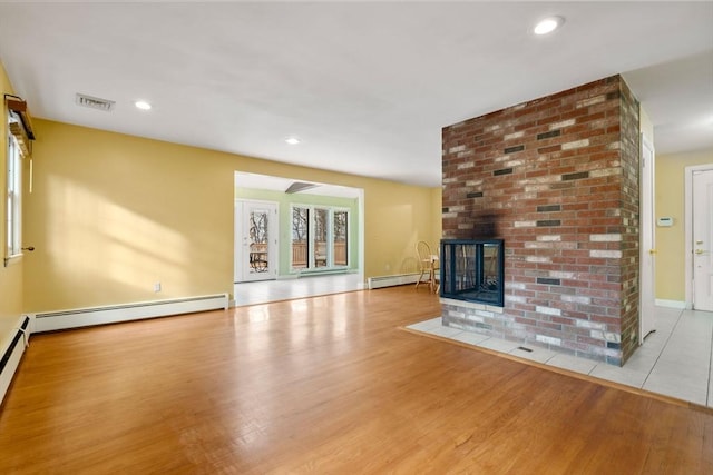 unfurnished living room with a fireplace, light hardwood / wood-style floors, and baseboard heating