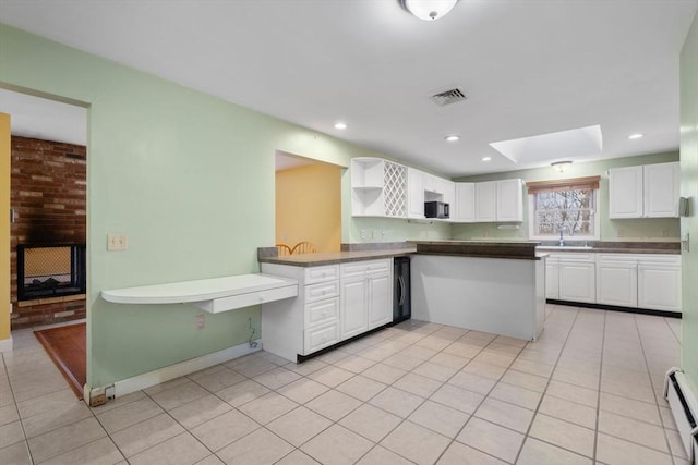 kitchen featuring a baseboard heating unit, kitchen peninsula, sink, a skylight, and white cabinetry