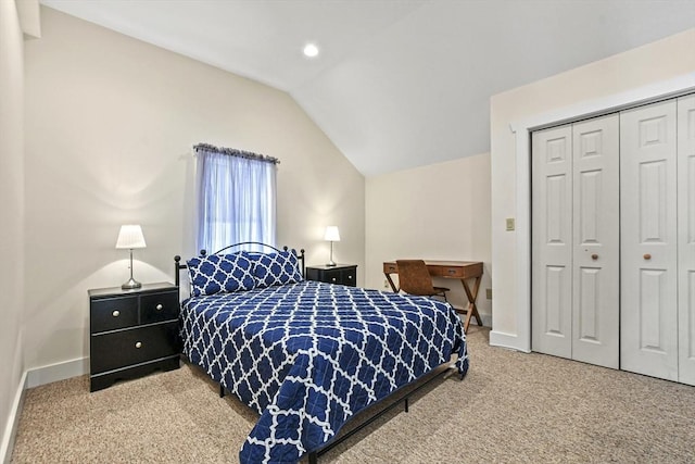 carpeted bedroom featuring lofted ceiling, a closet, and baseboards