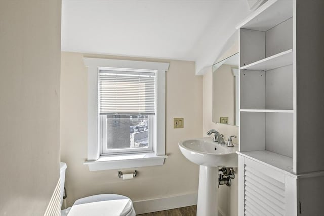 bathroom with a sink, toilet, baseboards, and wood finished floors